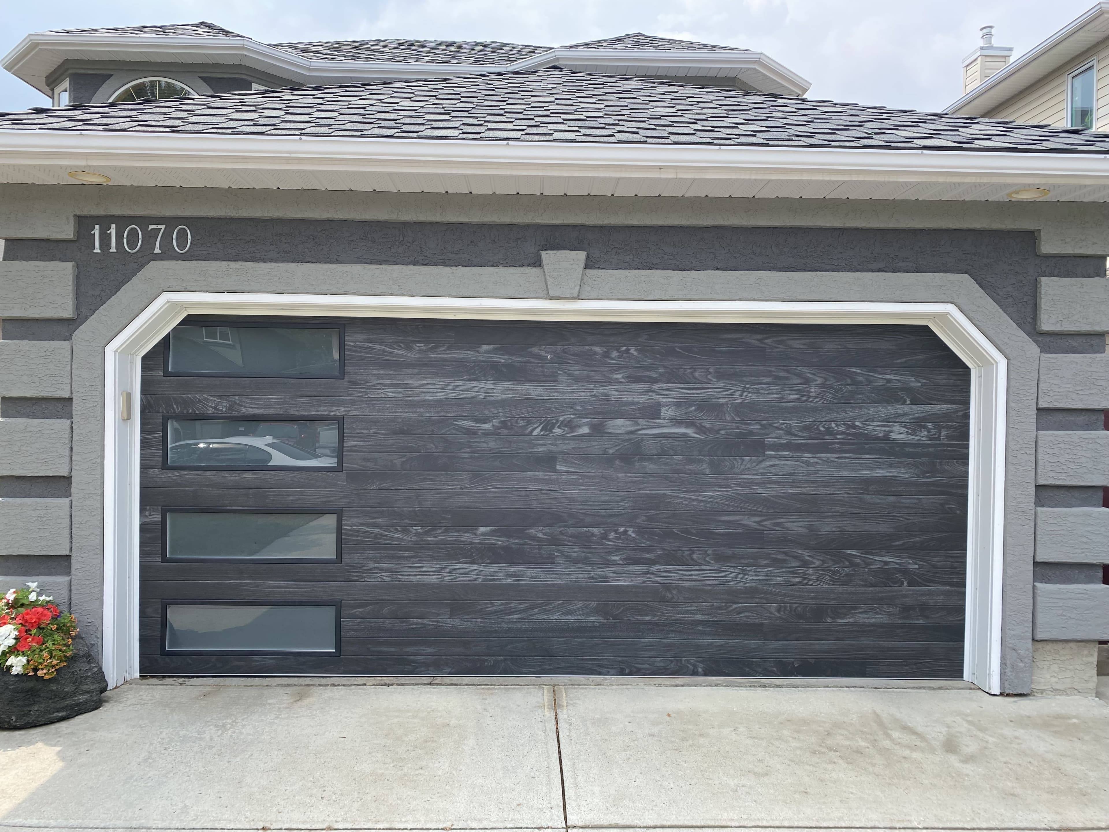 Technician inspecting a noisy off-track garage door in Calgary