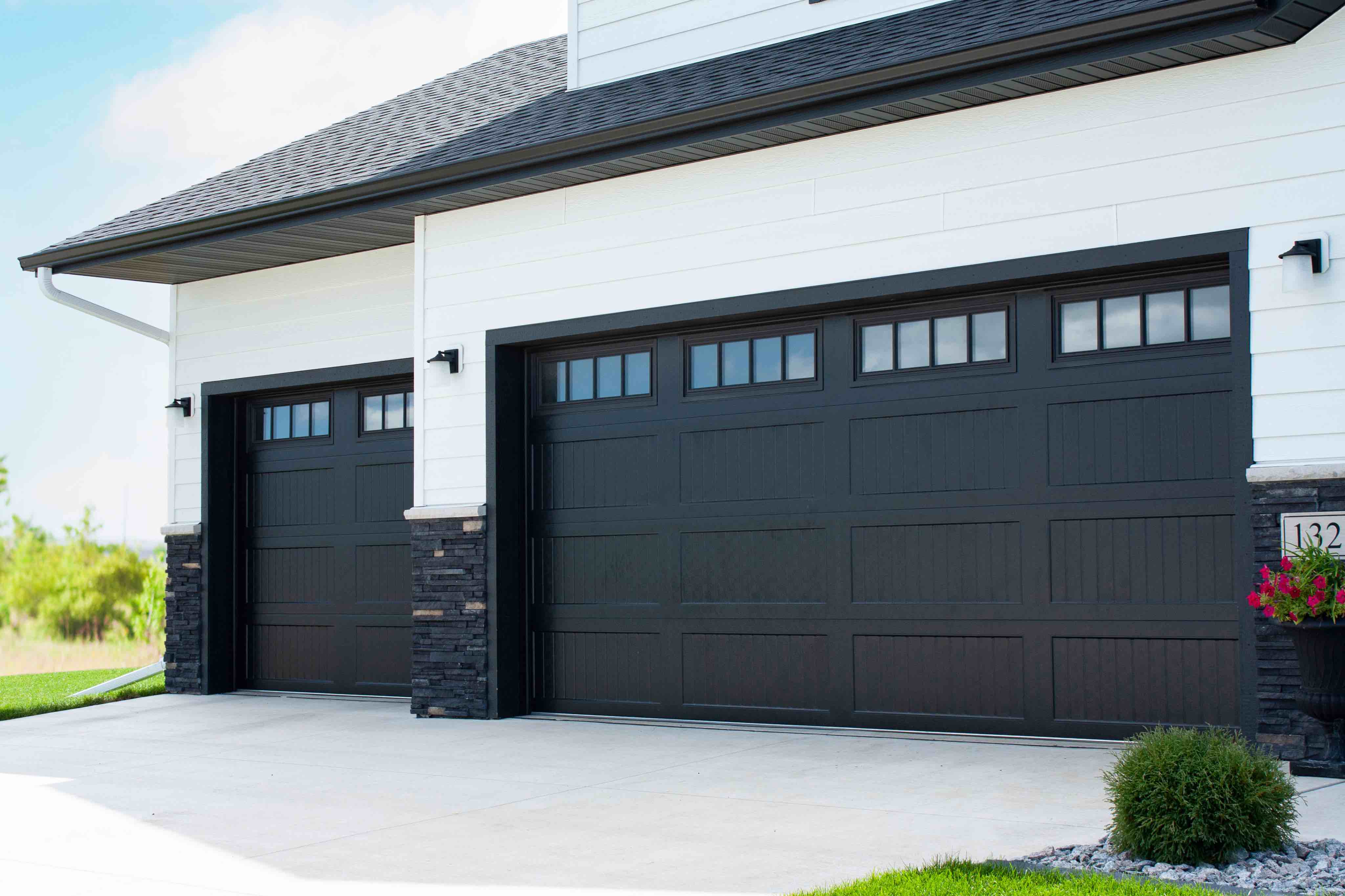 Technician applying garage door lubricant to hinges and rollers